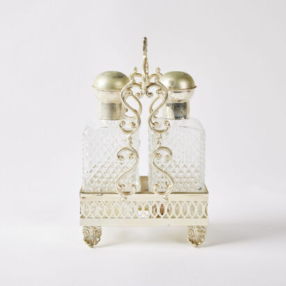 A Pair of Glass Bottles in an Ornate Gold Coloured Trug