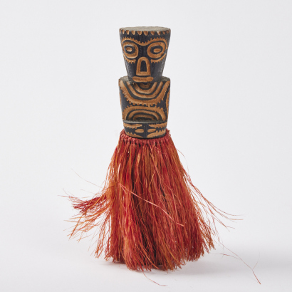 A Carved Decorative Figure with a Plant Fibre Skirt