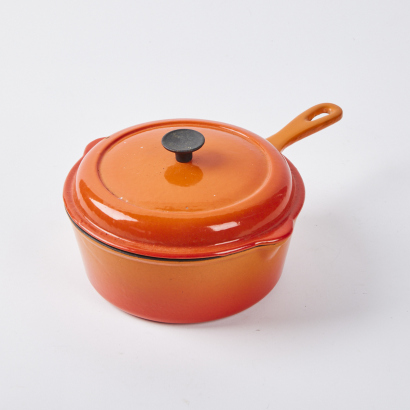 An Orange Le Creuset Lidded Saucepan