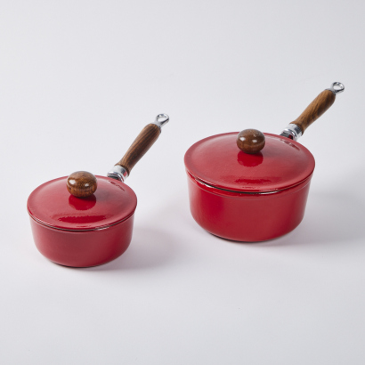 A Pair Of Cast Iron Sauce Pans With Red Enamel Coating