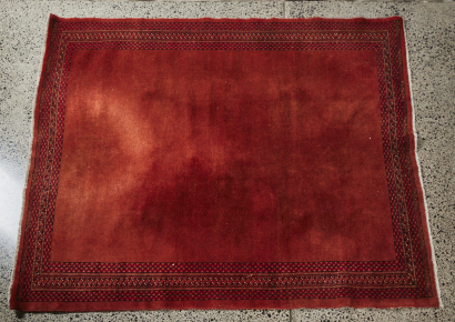 An Afghan Red Rug With Plain Ground And Border Decoration