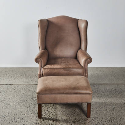 A Leather Wing Backed Chair With Foot Stool