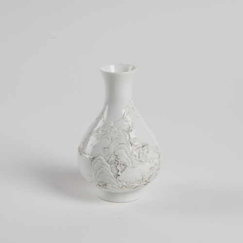 A Chinese Qing dynasty white carved porcelain vase with landscape pattern