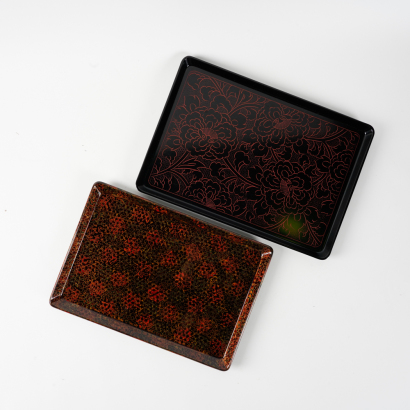 A set of two Japanese rectangular black lacquer patterned trays