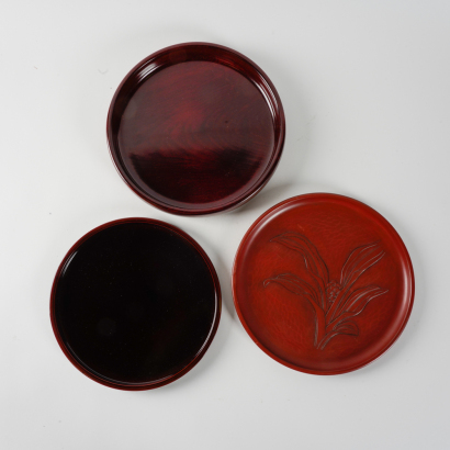 A set of four Japanese black and red lacquer round trays