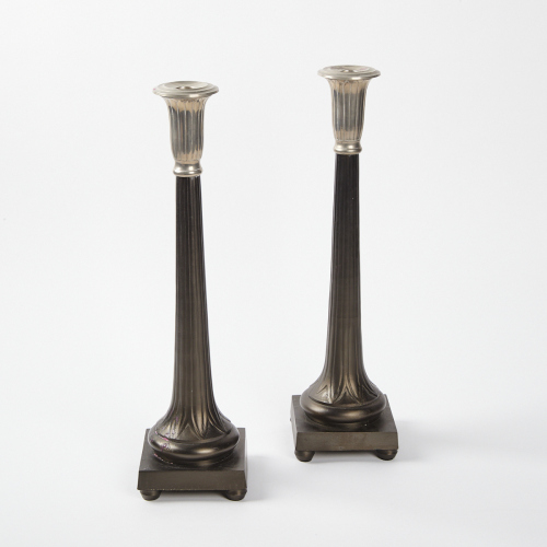 A Pair Of Cast Metal Candlesticks