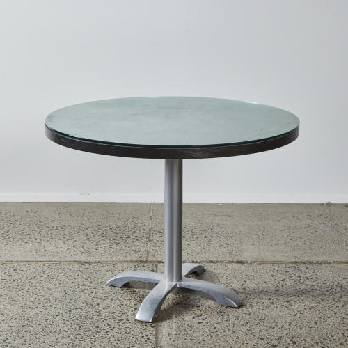 A Circular Dining Table With A Glass Overlay