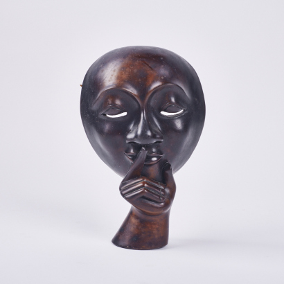 A Hardwood Carving Of A Whispering Face