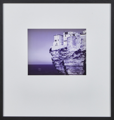 A Framed Black And White Photographic Print Of Cliffside Houses
