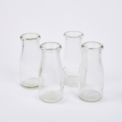 A Collection Of Four Vintage Milk Bottles