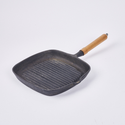 A Cast Iron Griddle With Wooden Handle