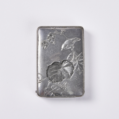 A late 19C-early 20C tin alloy 'flower and bird' match safe, Japan