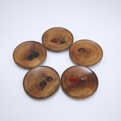 A set of five wooden tea saucers