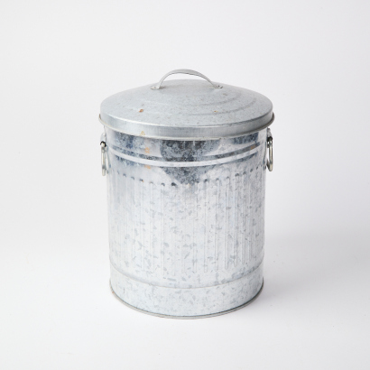 A Small Tin Trash Can With Lid