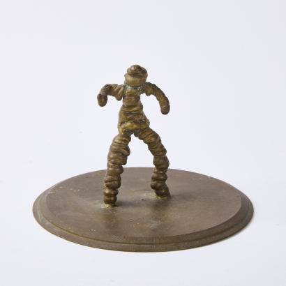 A Small Folk Art Brass Person On Plinth