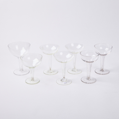 A Harlequin Set Of Seven Hollow Stemmed Champagne Coups