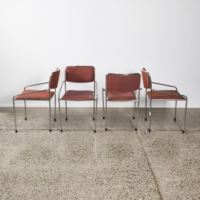 A Set Of Four Chrome Chairs With Red Upholstery