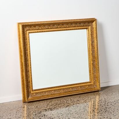 A Wall Mirror With Ornate Gold Frame