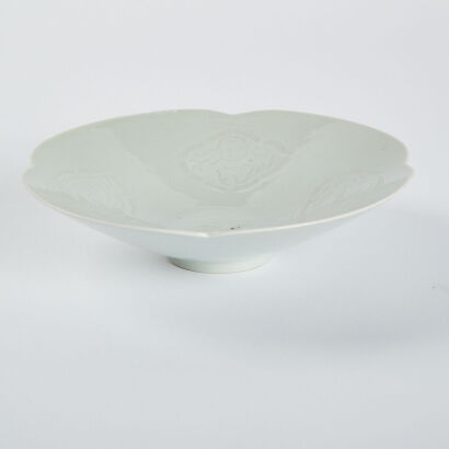 A Chinese white-glazed dark-carved sunflower dish with baby play pattern