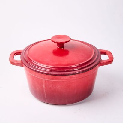 A Red Cast Iron Casserole Dish With Lid