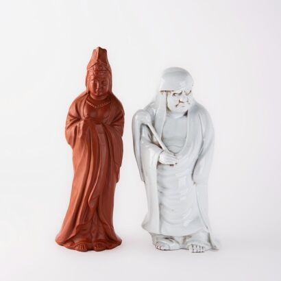 A Japanese 20th century white porcelain standing Dharma statue and A Japanese red glazed porcelain Guanyin statue (Tokoname)