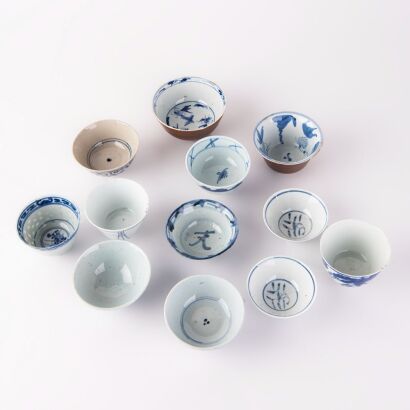 A group of twelve blue and white cups