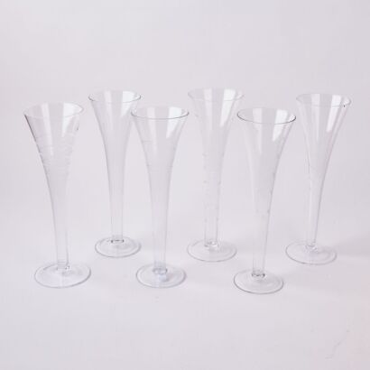 A Set Of Six Individually Etched Handblown Hollow Stem Champagne Flutes