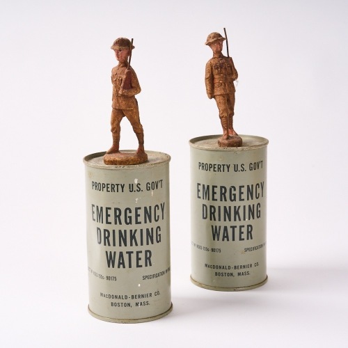 A Pair Of Emergency Drinking Water Cans With A Solider On Top