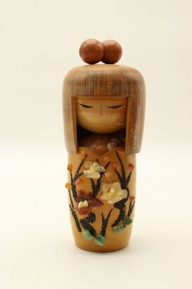 A Japanese vintage wooden doll decorated with stones