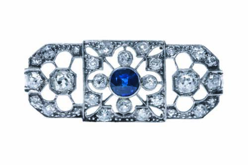 An Art Deco sapphire and diamond brooch, circa 1920's. Of rectangular, pierced design and set throughout with old and rose cut diamonds and a central round blue sapphire. Platinum. Weight 4.7 grams. Length 38mm.&nbsp;