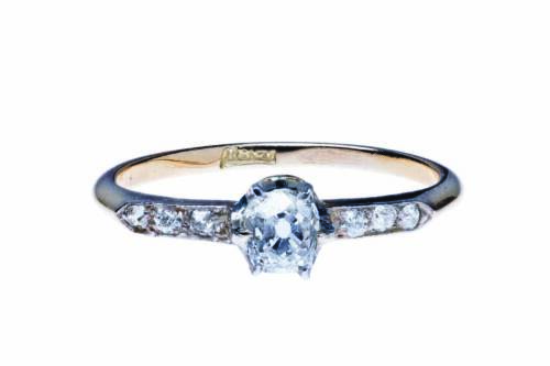 An antique solitaire diamond ring, claw set with an old mine cut diamond of estimated weight 0.30 carat, with diamond line shoulders. 18ct yellow gold and platinum. Weight 1.60 grams. Size L.&nbsp;