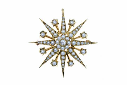 A Victorian pearl and diamond brooch, of starburst design, set throughout with small half pearls and a central old brilliant cut diamond. 15ct yellow gold. Weight 8.16 grams. Diameter 4cm.