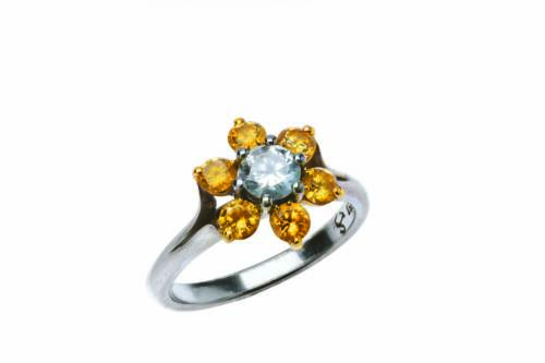 A yellow and white diamond cluster ring, the central white brilliant cut diamond of estimated weight 0.50 carat, surrounded by six yellow round brilliant cut diamonds of estimated total diamond weight 0.98 carats. 18ct white gold. Weight 6.4 grams. Size O