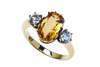 A topaz and diamond ring, the three stone ring claw set with a central oval golden topaz and shouldered by old brilliant cut diamonds. 18ct yellow gold. Weight 5.23 grams. Size O.&nbsp;