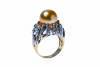 A South Sea pearl and diamond ring, set with an off round golden pearl measuring 12.8mm, in a pierced diamond set mount. Estimated total diamond weight 0.25 carat. 14ct yellow gold, rhodium plated. Weight 14.1 grams. Size P.