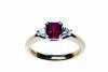 A ruby and diamond ring, four claw set with a square step cut ruby of estimated weight 1.19 carats, set either side with a trilliant diamond of estimated weight 0.10 carat. 18ct yellow gold. Weight 4.60 grams. Size M&frac12;.