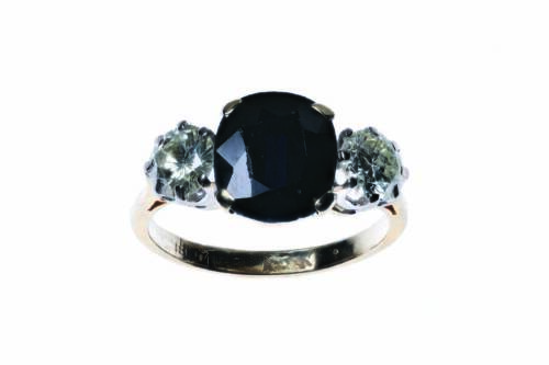 A sapphire and diamond ring, claw set with a central oval blue sapphire of estimated weight 3.55 carats, set either side with a modern round brilliant cut diamond of estimated weight 0.55 carat. 18ct yellow gold. Weight 4.10 grams. Size L.