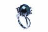 A Tahitian pearl and diamond ring, the central round pearl measuring 13mm in an abstract design mount. Estimated diamond weight 0.25 carat. 18ct white gold. Weight 9.28 grams. Size M. 