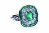 An Art Deco style emerald and diamond ring, the central bezel set rectangular step cut emerald of estimated weight 1 carat, surrounded by a line of twelve old European cut diamonds of estimated weight 0.70 carats and a further line of thirty-two calibre c