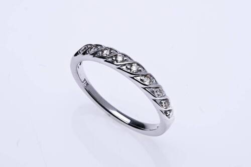A diamond band ring, set nine across with round brilliant cut diamonds. Estimated diamond weight 0.18 carat. 18ct white gold. Weight 2.53 grams. Size N.