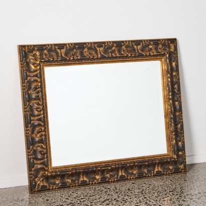 A Wall Mirror With Heavy Ornate Frame