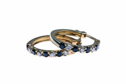 A pair of sapphire and diamond hoop earrings, the front section set with alternating blue sapphires and diamonds. Known diamond weight 0.29 carat. 9ct yellow gold. Weight 2.69 grams. Diameter 17mm.