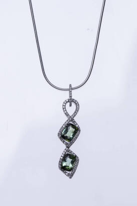 A tourmaline and diamond pendant, the drop pendant set with two rectangular facetted green tourmalines in a diamond twist mount, hung on a snake link chain. 9ct white gold. Weight 8.69 grams. Length of pendant 4cm.