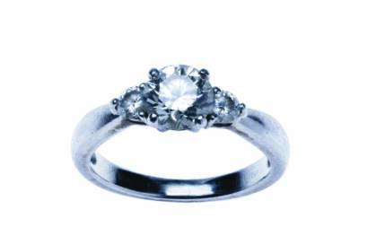 A diamond ring, four claw set with a central round brilliant cut diamond of estimated weight 0.82 carat with two 0.10 carat round brilliant cut diamonds on either side. Platinum. Weight 4.8 grams. Size J.