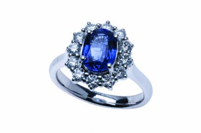 A Ceylonese sapphire and diamond ring, the central oval blue sapphire of known weight 2.11 carats, surrounded by claw set round brilliant diamonds of known weight 0.80 carat. 18ct white gold. Weight 5.95 grams. Size N.