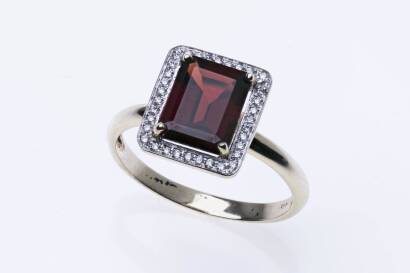 A garnet and diamond ring, four claw set with a rectangular garnet in a brilliant cut diamond set frame. 9ct yellow gold. Weight 2.52 grams. Size M.