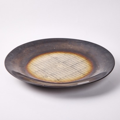 A Large Decorative Ceramic Plate With Weave Pattern Motif