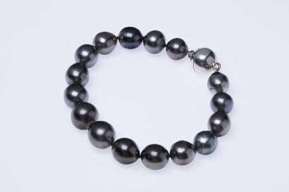 A Tahitian pearl bracelet, the sixteen off round to baroque pearls measuring 9 - 12mm, hung with a plain polished sterling silver magnetic ball clasp. Length 21cm.