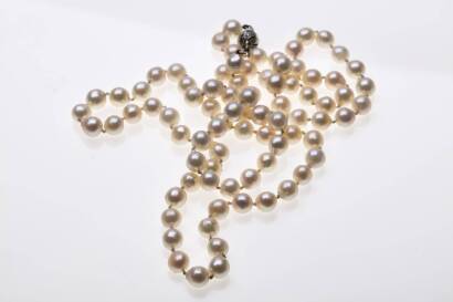 A cultured pearl necklace, the eighty-five semi-round to baroque pearls measuring 7.8mm - 8.6mm, hung with a silver and white sapphire set ball clasp. Length 84cm.