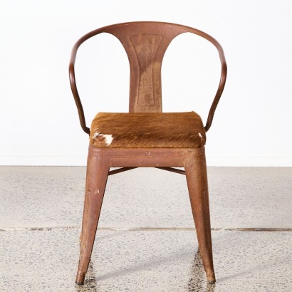 An Industrial Metal Chair With Cowhide Upholstery